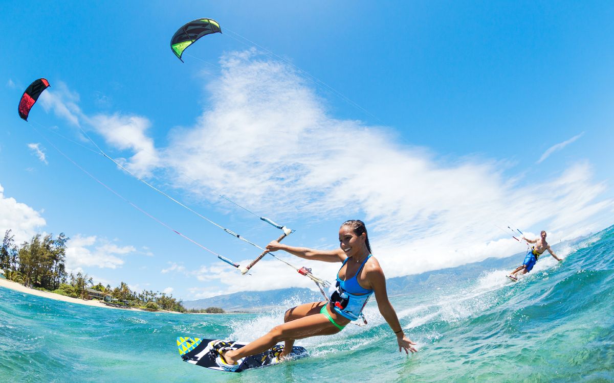 woman in blue and black bikini top and blue shorts surfing on sea waves during daytime