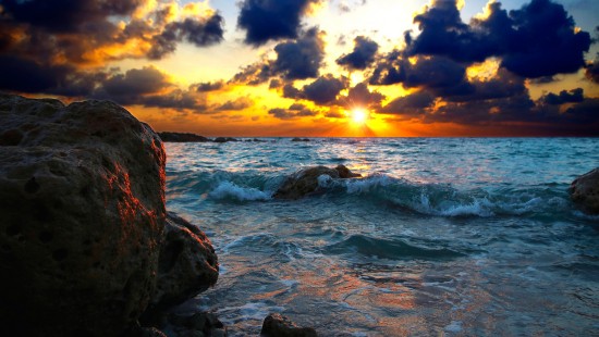 Image rocky shore under cloudy sky during sunset