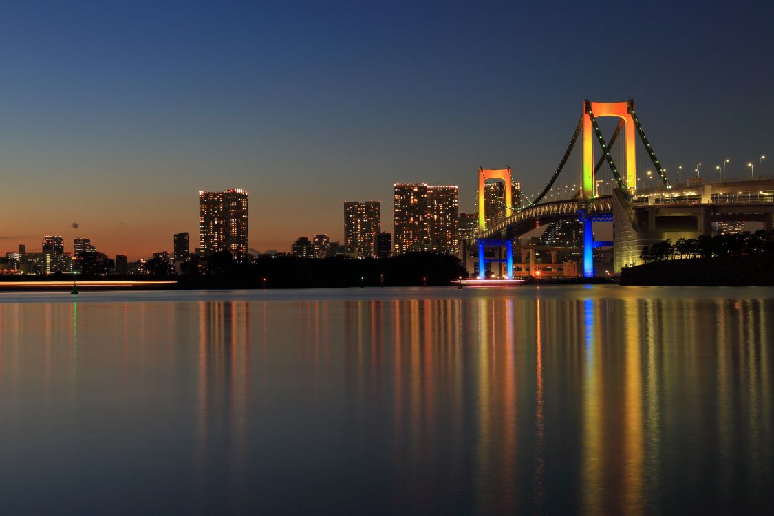 Beleuchtete Brücke Über Wasser Während Der Nacht Night. Wallpaper in 5458x3638 Resolution