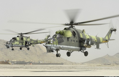 Image green and black helicopter on gray concrete ground during daytime