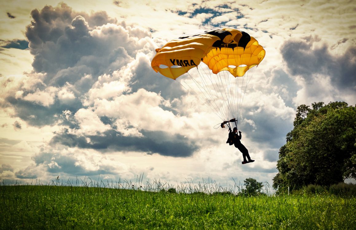 Person in Black Jacket and Pants Riding Yellow Parachute Under White Clouds During Daytime. Wallpaper in 5311x3435 Resolution