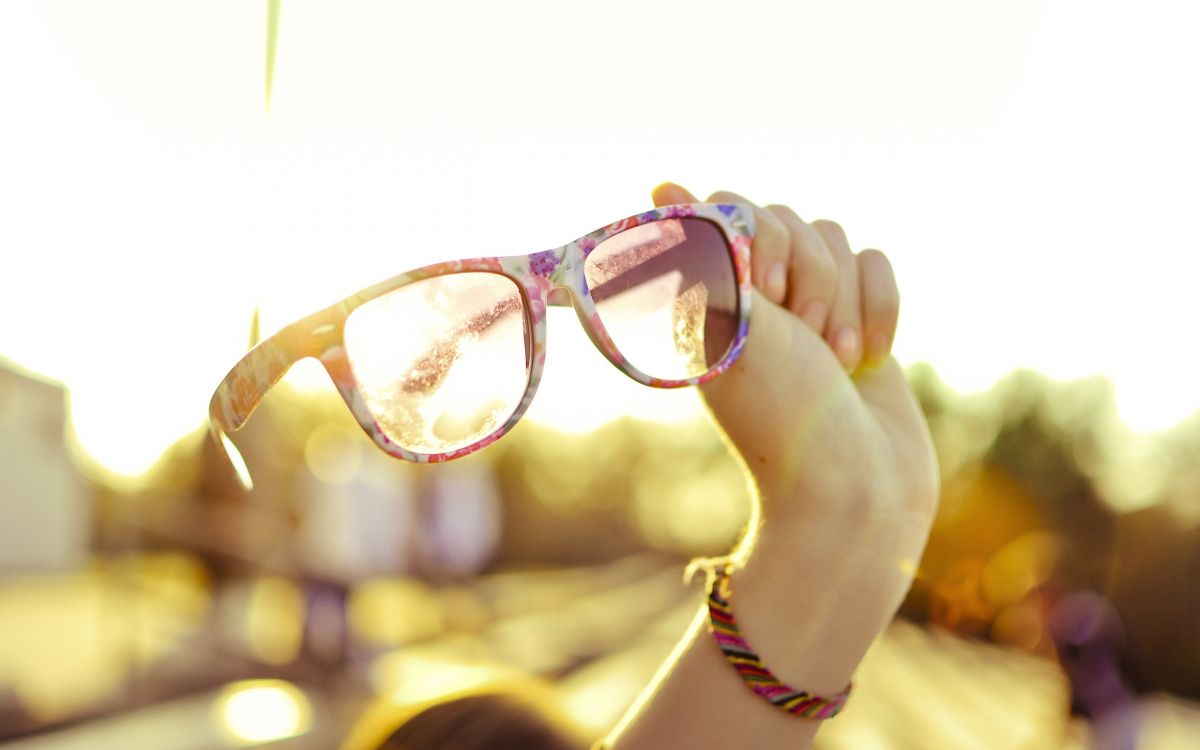 person holding brown framed eyeglasses