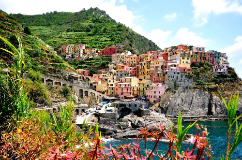 Image houses near green mountain and body of water during daytime