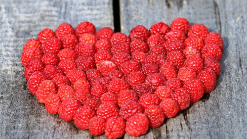 Image red raspberries on brown wooden table