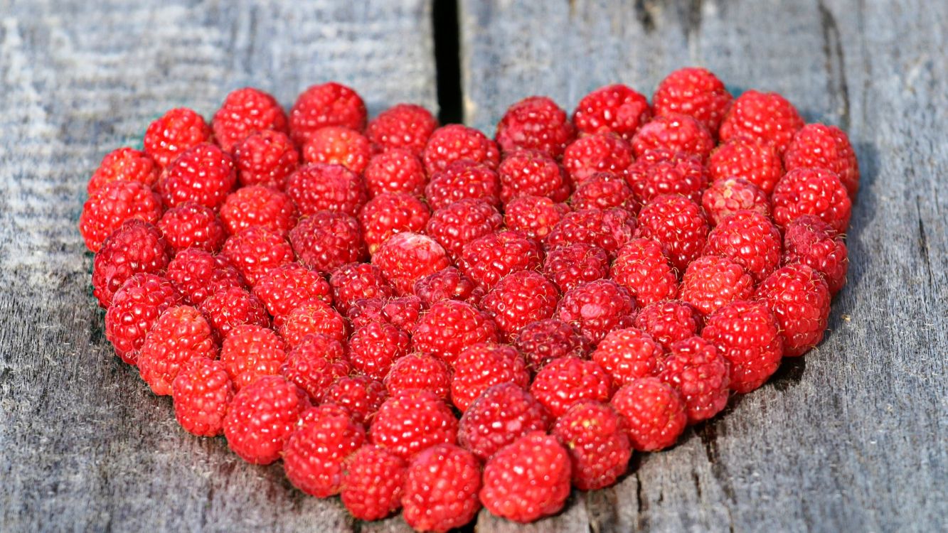 red raspberries on brown wooden table