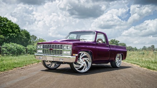 Image red chevrolet single cab pickup truck on gray asphalt road under white clouds and blue sky