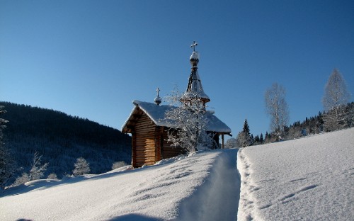 Image brown wooden house on snow covered ground under blue sky during daytime