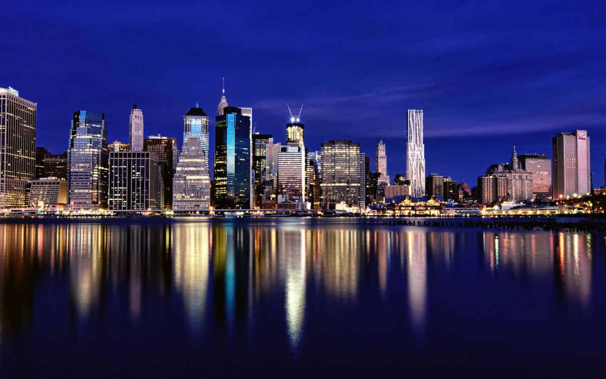 Skyline Der Stadt Über Gewässer Während Der Nacht. Wallpaper in 2560x1600 Resolution