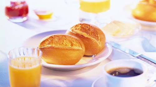 Image bread on white ceramic plate beside clear drinking glass