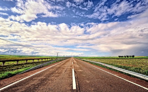 Image gray concrete road under blue sky and white clouds during daytime