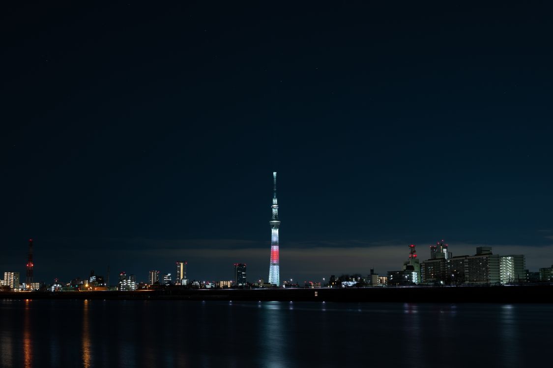 White and Red Tower Near Body of Water During Night Time. Wallpaper in 6000x4000 Resolution
