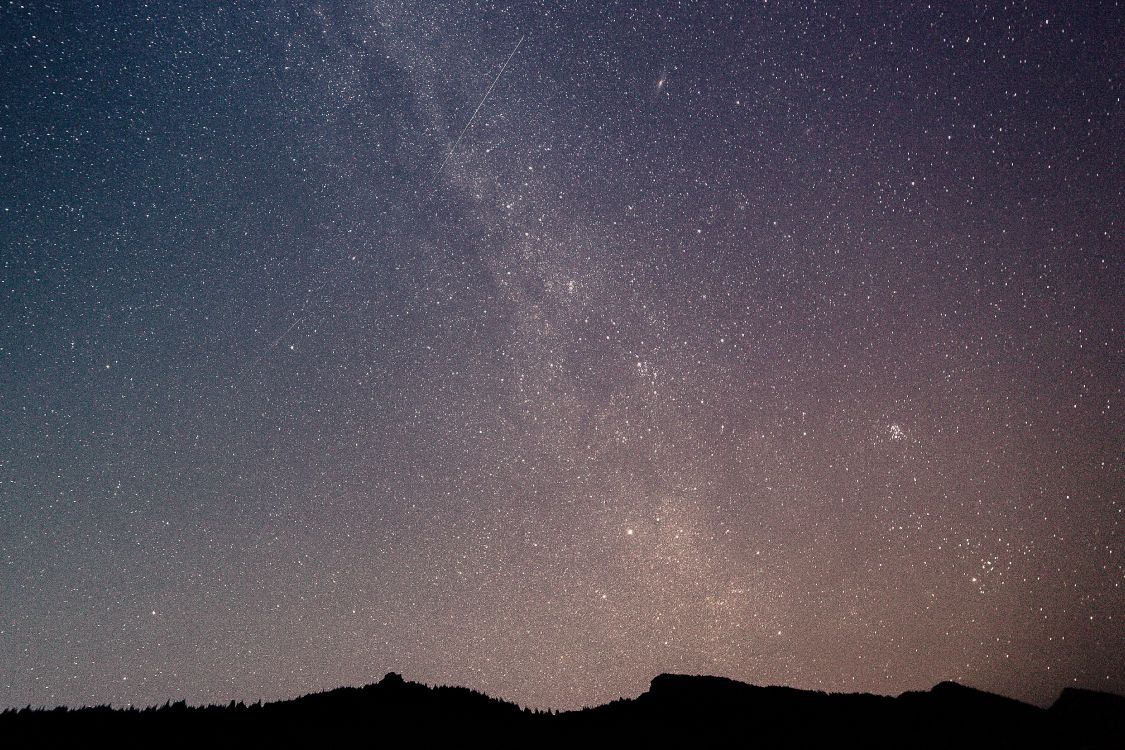 silhouette of mountain under starry night