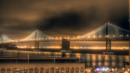 Image lighted bridge over body of water during night time