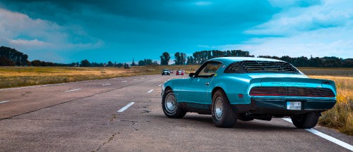 Image teal car on gray asphalt road during daytime