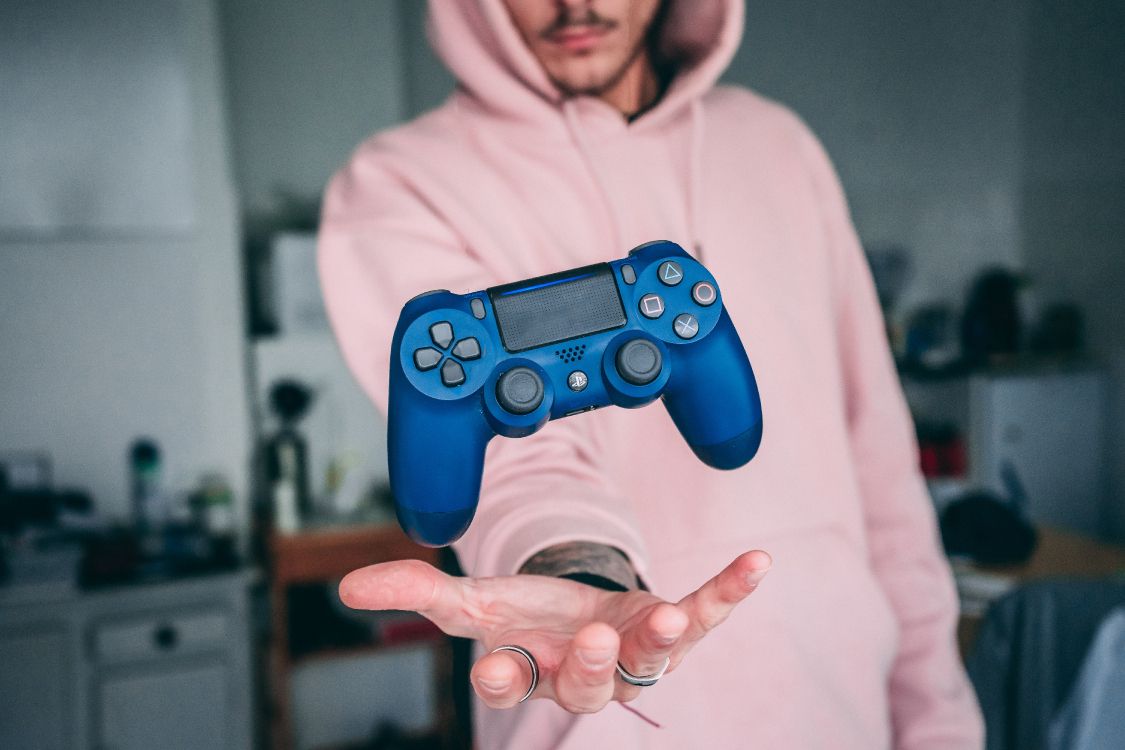 Man in White Hoodie Holding Blue Sony ps 4 Controller. Wallpaper in 6000x4000 Resolution