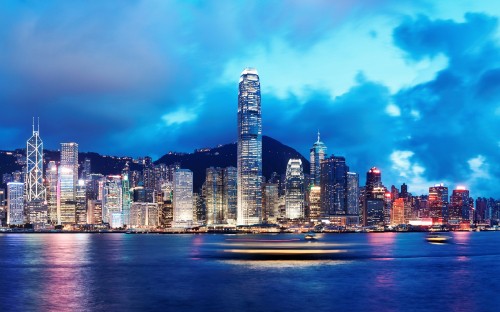 Image city skyline across body of water during night time