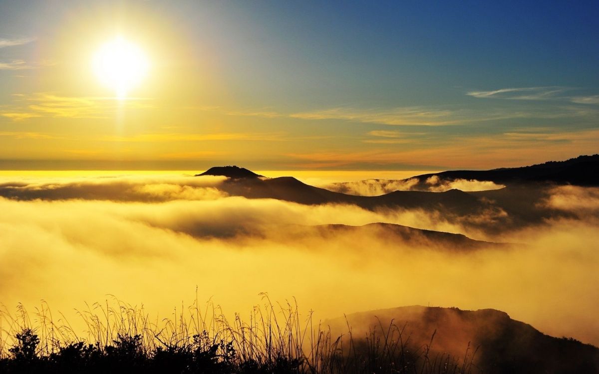 silhouette of mountain under cloudy sky during sunset