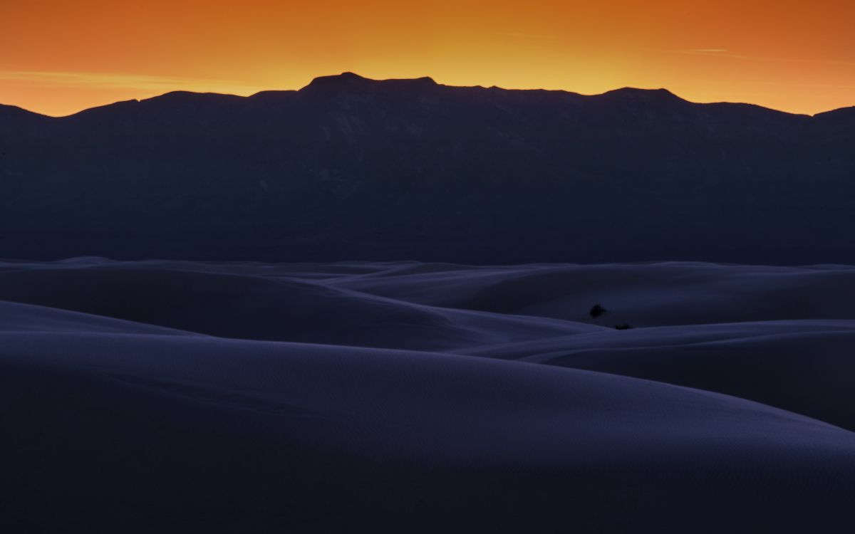 snow covered mountain during sunset