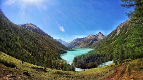 Image green lake in the middle of mountains during daytime