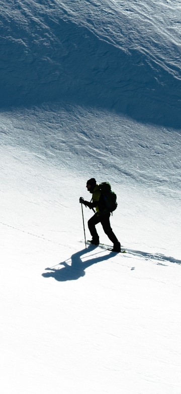 Image man in black jacket and pants riding on snowboard during daytime