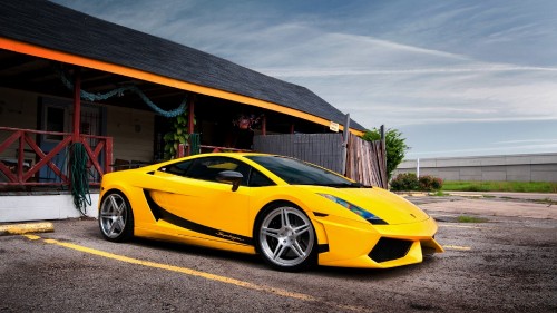 Image yellow lamborghini aventador parked near brown wooden building during daytime