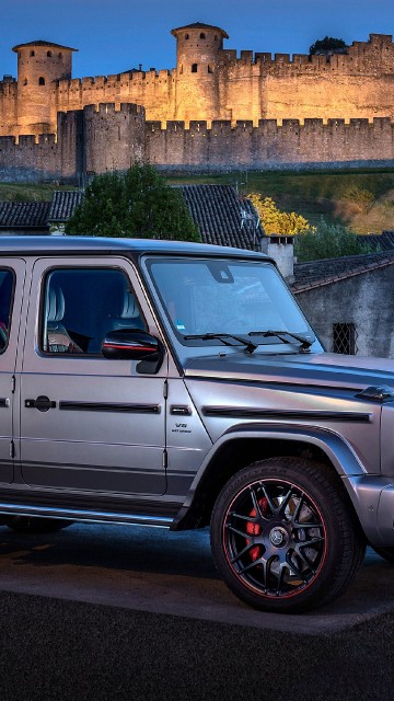 Image gray suv parked beside brown concrete building during daytime