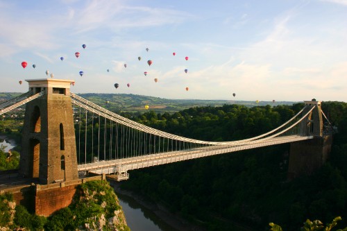 Image birds flying over bridge over river during daytime