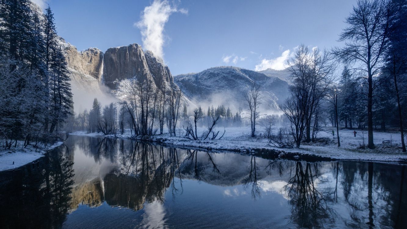 snow covered mountain near body of water during daytime