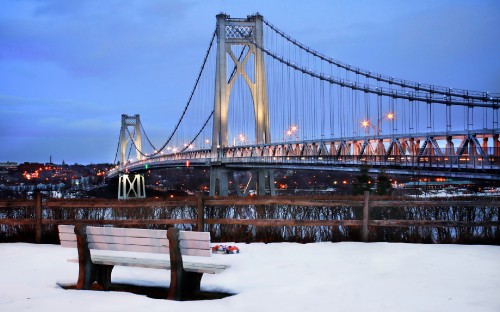 Image brown wooden bench near bridge during daytime