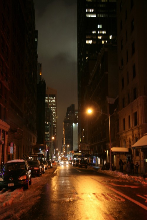 Image cars on road between high rise buildings during night time