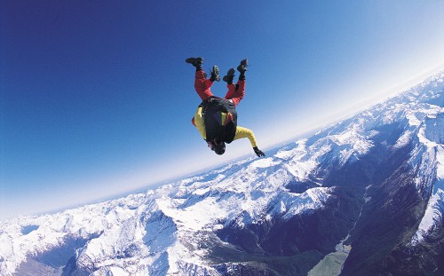 Image man in black jacket and black pants jumping on snow covered mountain during daytime