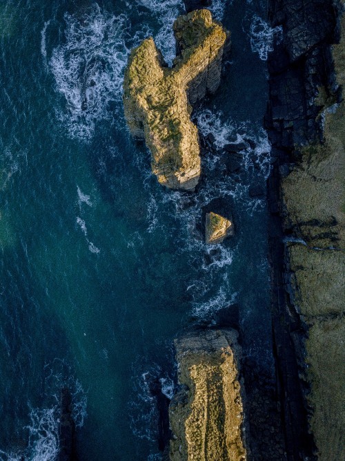 Image brown rock formation on body of water during daytime