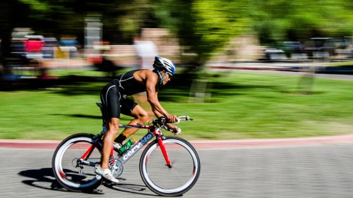 Image man in black shirt riding on red and black road bike