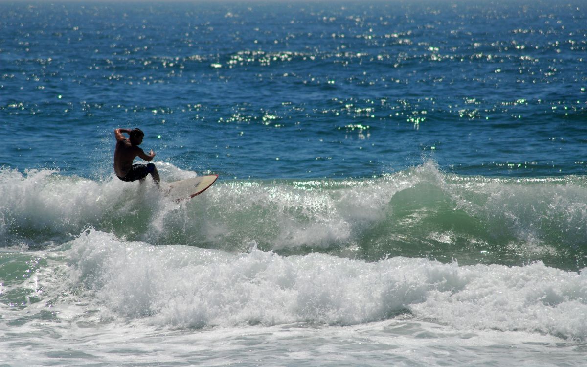 man surfing on sea waves during daytime