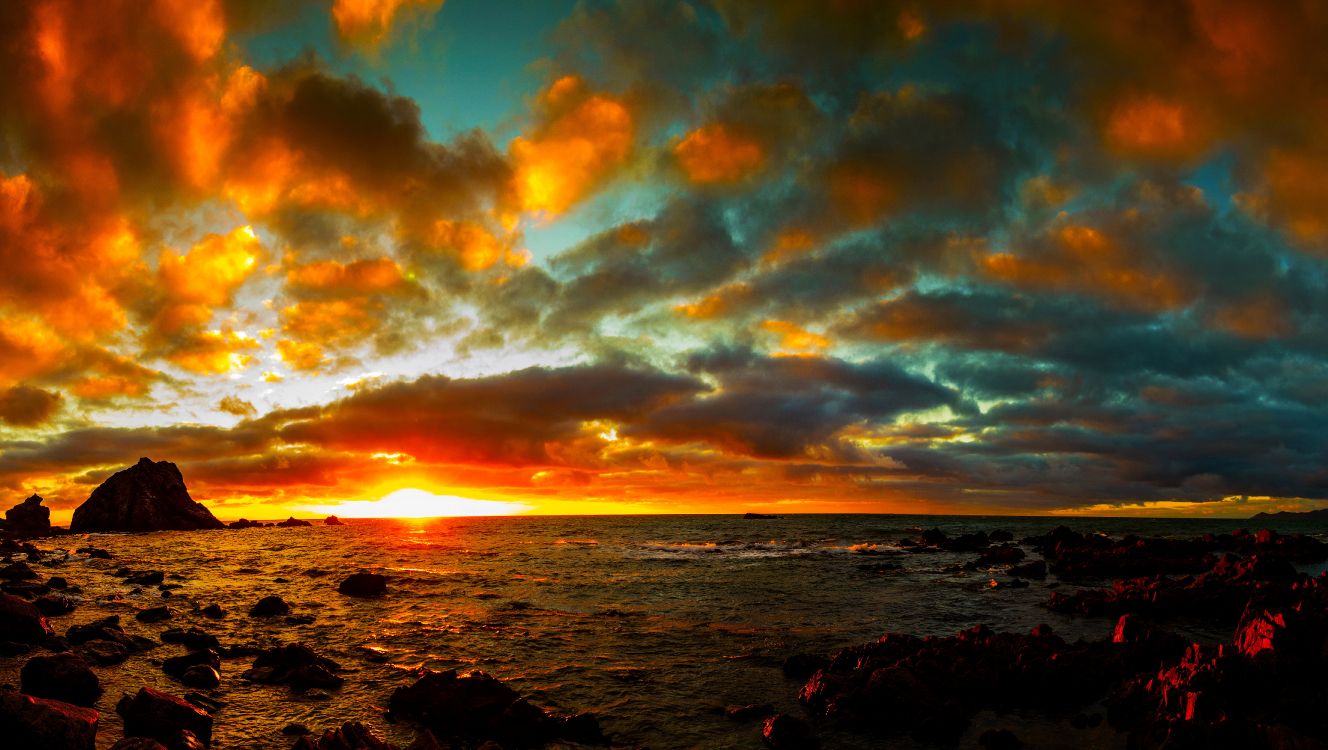 body of water under cloudy sky during sunset