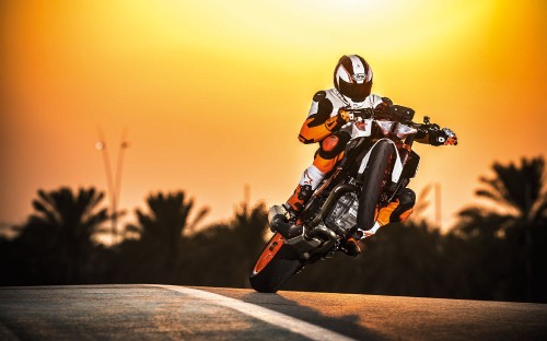 Image man in orange helmet riding orange and black motorcycle