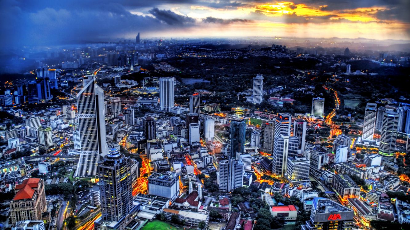 city skyline under orange and gray cloudy sky during sunset