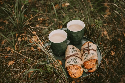 Image two white ceramic mugs on brown wooden log