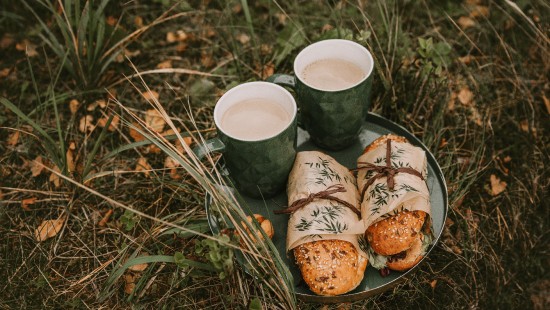 Image two white ceramic mugs on brown wooden log