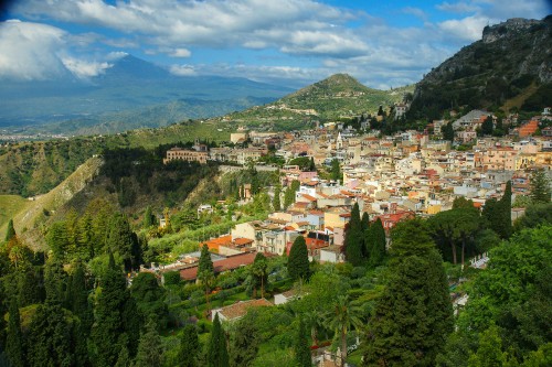 Image white and brown houses on green mountain under blue sky during daytime