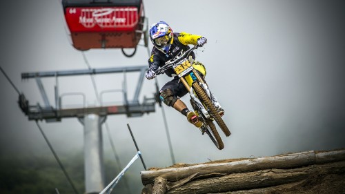 Image man in yellow and black suit riding yellow and black motocross dirt bike