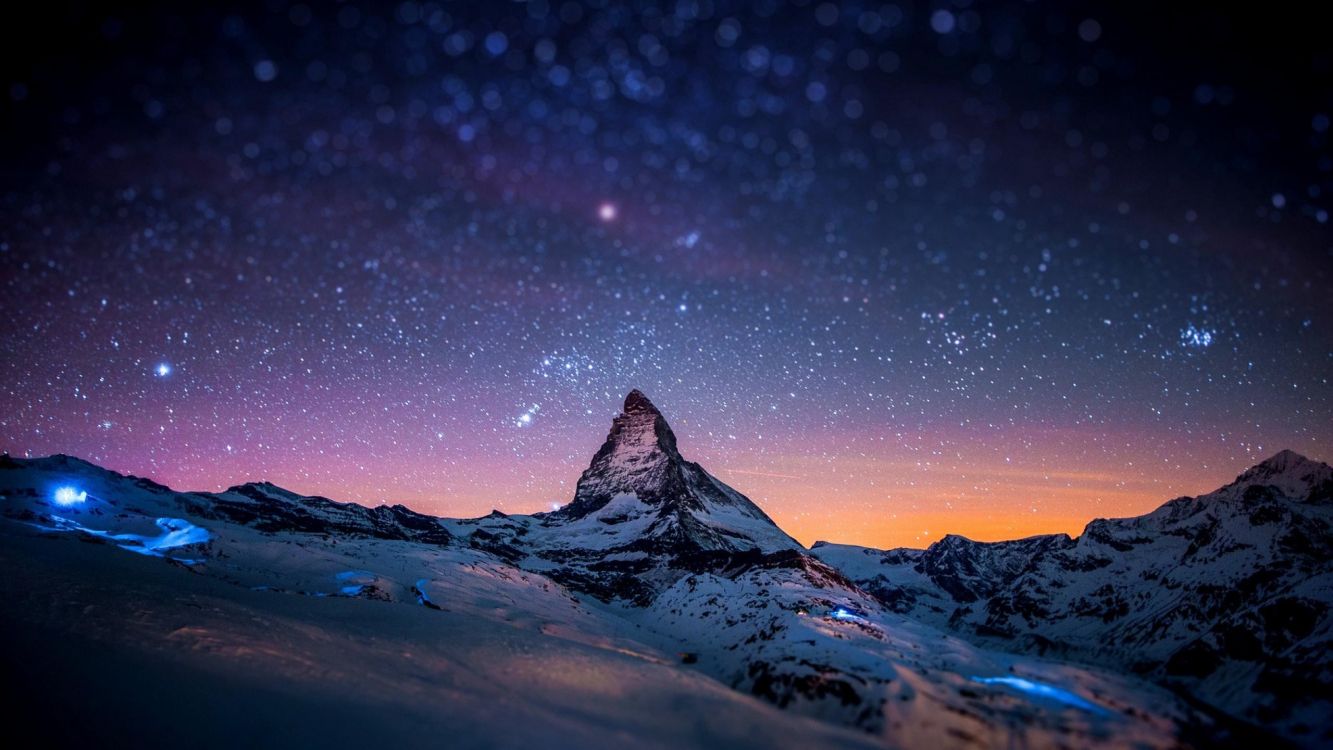 snow covered mountain under starry night