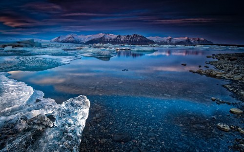 Image rocky mountain near body of water during daytime