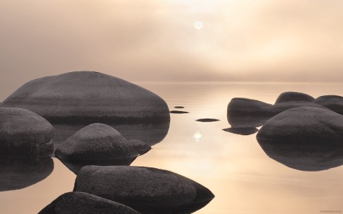 Image gray rock formation on body of water during daytime