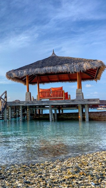 Image brown wooden house on sea shore during daytime