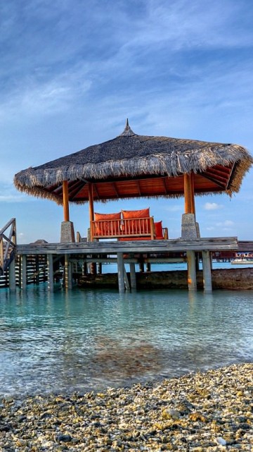 Image brown wooden house on sea shore during daytime