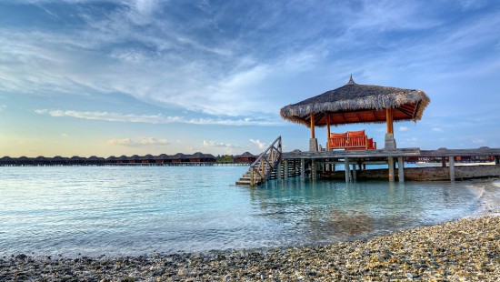 Image brown wooden house on sea shore during daytime