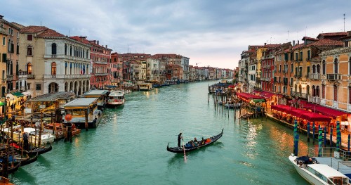 Image people riding on boat on river near buildings during daytime