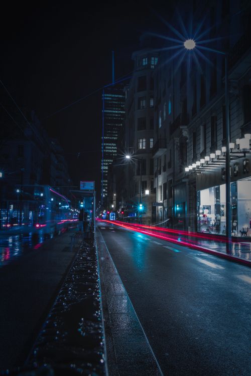 cars on road between buildings during night time