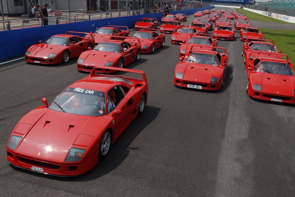 Voiture de Sport Ferrari Rouge Garée Sur un Parking Pendant la Journée. Wallpaper in 3872x2592 Resolution